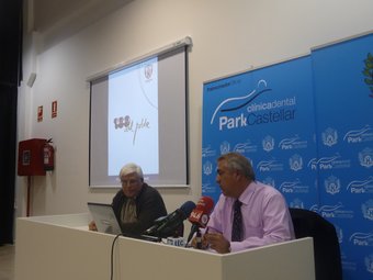 Albert Cornet i Rafel Germà, membres de la comissió organitzadora, tot fent la presentació amb el logotip del centenari al fons. M.C.B.