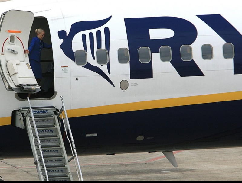 Una hostessa de la companyia de baix cost Ryanair en el moment que tancava la porta de l'avió a l'aeroport Girona Costa Brava. MANEL LLADÓ