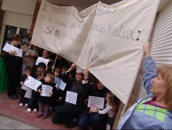 L'equip directiu de la llar d'infants La Quitxalla, ahir a la sortida de classes,  amb alguns pares i escolars del centre i la pancarta amb què van protestar a Tarragona A. ESTALLO