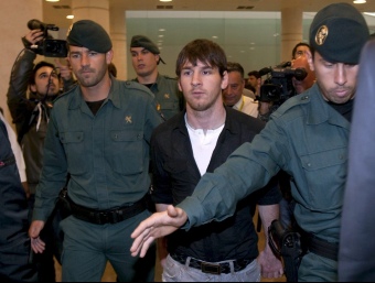 Messi, ahir a l'aeroport del Prat flanquejat per membres del cos de la Guàrdia Civil.  EFE