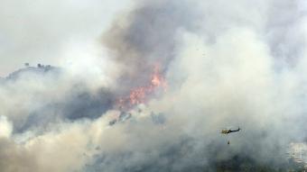 Un helicòpter s'acosta a les flames, el passat dissabte. EFE