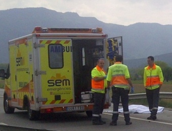 Sanitaris i mossos al costat de la víctima, en el lloc de l'accident, a la recta de Les Preses JOAN GUIRADO / ACN