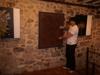 Àngel Pairó, amb una de les seves pintures el dia de la inauguració de l'exposició a Can Vayreda. EL PUNT
