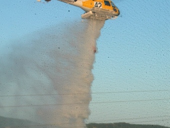Un helicòpter apagant el foc, ahir. JOAN SABATER