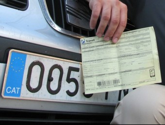 Un conductor mostra una multa que li van posar perquè duia l'adhesiu del CAT EL PUNT AVUI