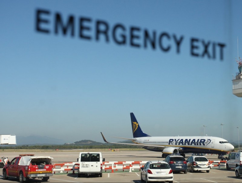 Un avió de Ryanair i la torre de control de l'aeroport, en una imatge presa des d'un autobús. LLUÍS SERRAT