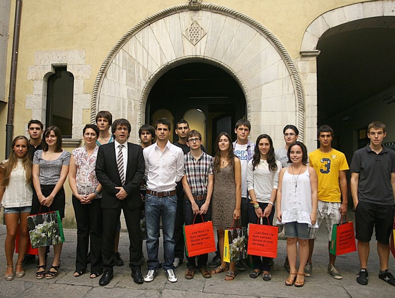 L'alcalde de Girona, Carles Puigdemont, amb el jove Marc Capilla, guanyador del premi Yuz i els estudiants que aquest any han obtingut les millors notes de selectivitats en els seus instituts. MANEL LLADÓ