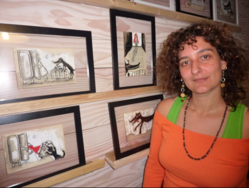Laia Juez amb algunes de les seves il·lustracions de La caputxeta vermella, a la botiga Contes Savis. R. E