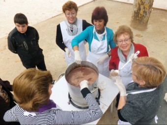 Unes dones preparen un perol de xocolata en el marc de la Fira. B. SILVESTRE
