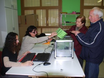 Uns veïns dipositen el seu vot en una de les urnes ahir al Palau d'Anglesola