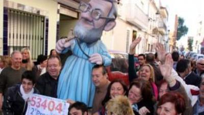 Afortunats amb participacions del segon premi de la Rifa de Nadal que va repartir l'organització del PP de Manises celebren el premi traient un ninot de Rajoy al carrer ACN