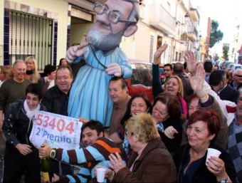 Afortunats amb participacions del segon premi de la Rifa de Nadal que va repartir l'organització del PP de Manises celebren el premi traient un ninot de Rajoy al carrer ACN