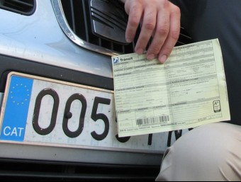 Un home mostra una multa de trànsit que li van posar perquè portava l'adhesiu CAT a la matrícula del seu turisme ARXIU