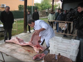 Narcís Torrentà, d'Embotits Pagès, desfà el porc, ahir al migdia a la plaça del poble de Canet d'Adri, en la festa de la matança. J.F.