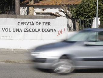 Una imatge d'ahir al matí de la pancarta a l'entrada de Cervià, en què es demana millores a l'escola del poble. LLUÍS SERRAT