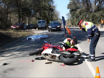Els mossos inspeccionen la moto en primer terme amb el cos de la víctima encara a la carretera i al fons, la furgoneta amb que va xocar. XAVIER PI/ ACN