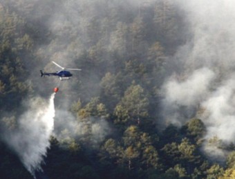 Un helicòpter bombarder treballant en les tasques d'extinció de l'incendi de Baix Pallars, ahir, quan estava previst tenir-lo controlat a l'entrada de nit MARTA LLUVICH / ACN