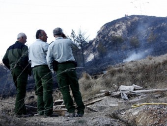Tres agents rurals observen el perímetre d'un incendi a la Ribera de Montardit, a Sort ACN