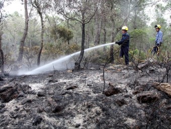 Un bomber remullant les cendres ACN