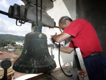 Un tècnic va instal·lar ahir un electromartell que temperarà els repics nocturns de la campana de la parròquia de Sant Joan d'Olesa i permetrà que torni a sonar durant la nit JUANMA RAMOS