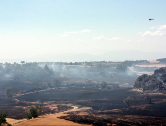 Un helicòpter sobrevolant l'àrea cremada, sobretot de camps de cereals, a Sant Guim de Freixenet O.BOSCH / ACN