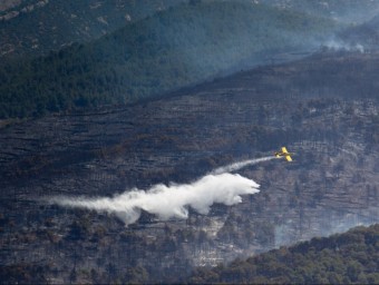 Un avió dels Bombers llança aigua damunt un dels fronts de l'incendi, aquest dijous al Parc Natural del Montsant JOSÉ CARLOS LEÓN