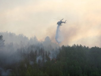 Un helicòpter bombarder descarrega aigua damunt el front de l'incendi, aquesta tarda Vilaverd EFE