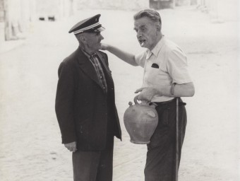 El músic (a la dreta), parlant amb un veí de Cantallops, perfectament integrat en l'ambient del poble ARXIU