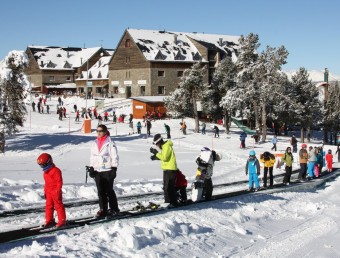 Un grup de joves esquiadors debutants gaudint ahir al matí del sol a la cinta remuntadora de Portainé ACN