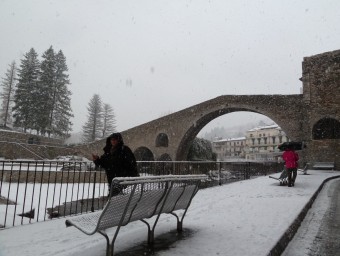 Una de les postals més típiques de Camprodon, el pont romànic i el carrer de Sant Roc ben emblanquinats per la nevada d'ahir al matí. J.C