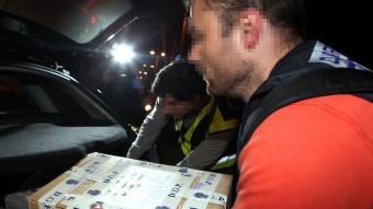 Agents de la policia espanyola carreguen caixes al cotxe després de l'escorcoll de la seu de l'agència de detectius Método 3 a Barcelona ACN