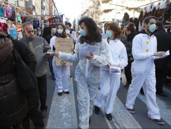 Activistes contra el fracking repartint octavetes al mercat de Vic. EL9NOU