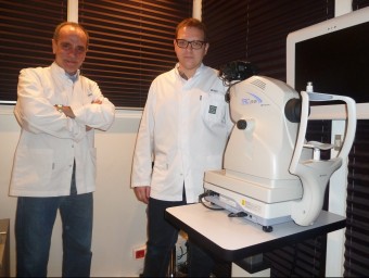 El propietari de l'Òptica Clarà d'Olot, Dani Aula, i un dels tècnics amb l'aparell de l'Optretina amb què realitzen la “fotografia” de l'ull del pacient. J.C