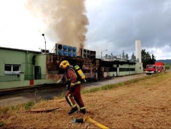 Els bombers treballant en l'extinció del foc que va causar molt defum. JOAN CASTRO/ ICONNA