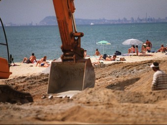 Les màquines treballen per posar sorra a la platja de Premià de Mar l'any 2011. ARXIU