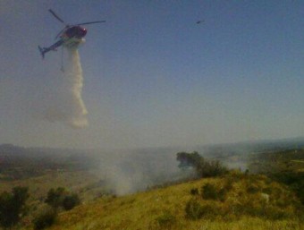 Un helicòpter treballant en les tasques d'extinció de l'incendi a Vartrolí, al límit dels terrenys militars ADF RAGAVI