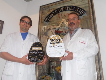 Marc Capdevila i Pere Capdevila, amb dues de les llaunes típiques del seu pernil més popular.  URE COMAS
