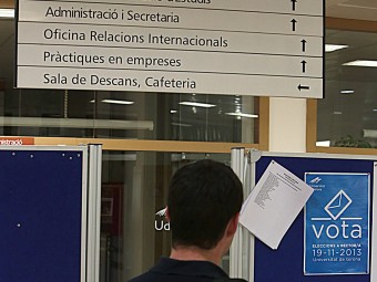 Un estudiant de la facultat d'Econòmiques, atent a un cartell informatiu de les eleccions a rector, divendres a la tarda MANEL LLADÓ