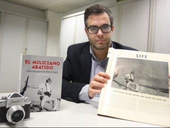Miquel Manzano amb el llibre, la revista ‘Life' de juliol del 1937 en què es va publicar la foto, i una càmera Zenit, l'equivalent rus de la Leica de Capa L. SERRAT