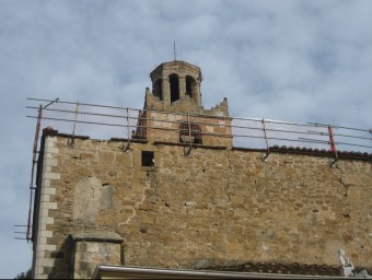 Una imatge de les baranes de protecció en la intervenció de la coberta de l'església de Cartellà i, al fons, el campanar, la setmana passada J. FERRER