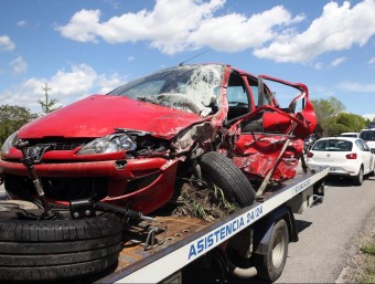 Una grua retira un dels vehicles implicats en l'accident, aquest diumenge a Sant Feliu de buixalleu JOAN CASTRO / ICONNA