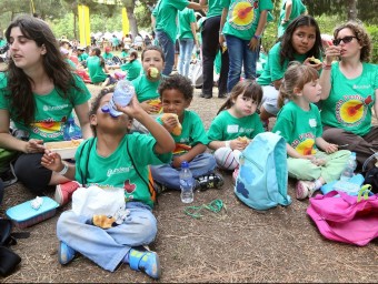 Un grup de nens i nenes d'un esplai dinant a la Festa Esplai d'ahir i lluint la samarreta solidària d'Un estiu per a tothom JUANMA RAMOS