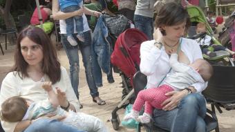 Dues dones alleten els seus fills ahir als jardins del Palau Robert de Barcelona  JOSEP LOSADA