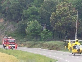 Els serveis d'emergències atenent al ferit a peu de carretera i l'helicòpter medicalitzat a punt per traslladar-lo a l'hospital Josep Trueta de Girona. GEMMA SÀNCHEZ