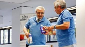 Voluntaris de l'Obra Social la Caixa classificant aliments de donatius REDACCIÓ