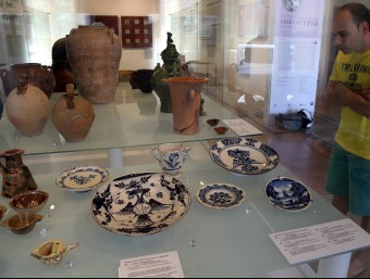 Un jove contempla algunes de les peces de ceràmica que formen part de l'exposició JUANMA RAMOS
