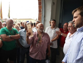 Veïns de les urbanitzacions, en la manifestació pels talls de l'aigua que van fer el 26 de juny. A la dreta, l'alcalde, Jordi Camps. LLUÍS SERRAT