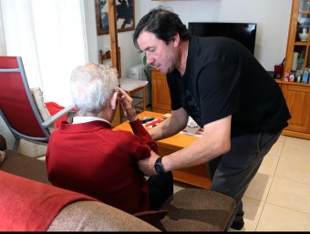 Un voluntari del programa d'atenció a la gent gran d'Arbúcies ajuda un avi, en el seu domicili MANEL LLADÓ