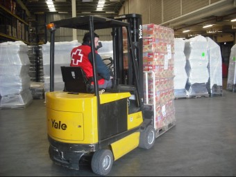 Un voluntari de la Creu Roja transportant aliments preparats per ser distribuïts ARXIU