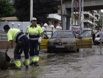 Treballadors municipals netegen un carrer inundat, aquest divendres a Calafell JOSÉ CARLOS LEÓN